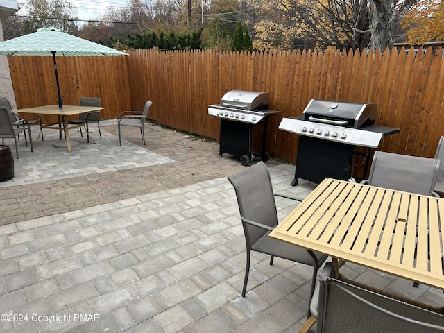 view of patio / terrace with a grill, fence, and outdoor dining space