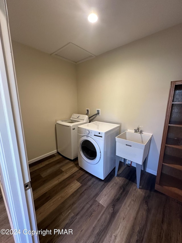 washroom featuring baseboards, washing machine and dryer, dark wood-style floors, and laundry area