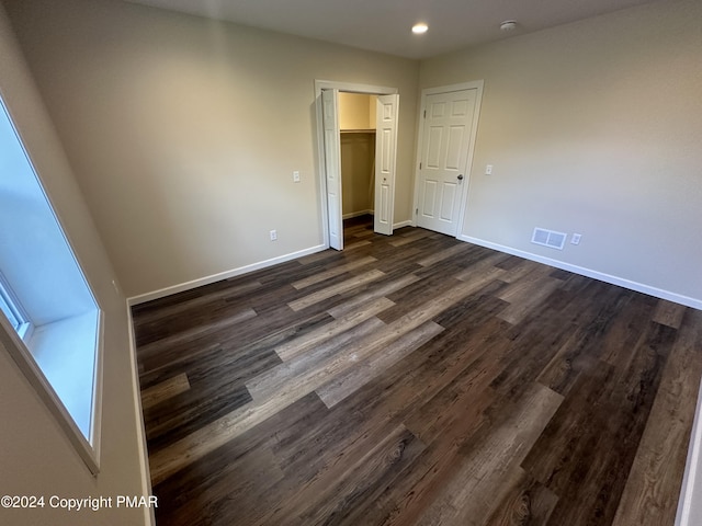 unfurnished bedroom featuring recessed lighting, dark wood-style floors, baseboards, and visible vents