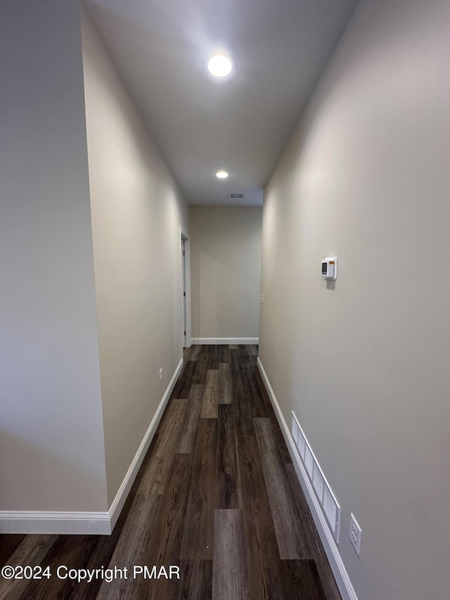 hallway with recessed lighting, visible vents, baseboards, and wood finished floors