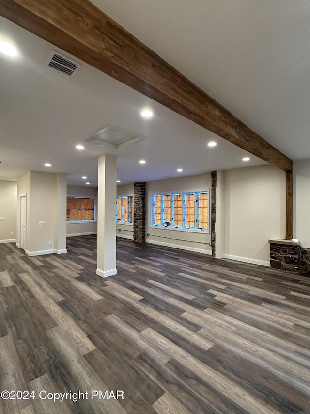 below grade area featuring dark wood finished floors, baseboards, visible vents, and recessed lighting
