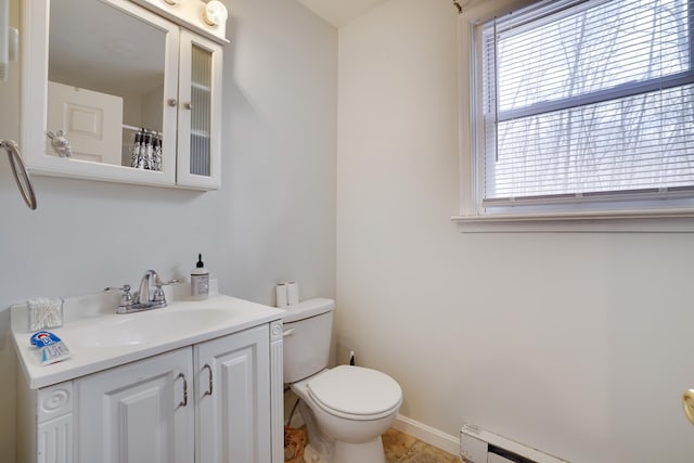 bathroom featuring a shower with shower curtain, toilet, a baseboard heating unit, vanity, and baseboards