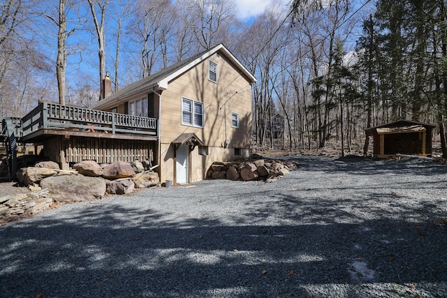 view of side of home with a chimney and a wooden deck