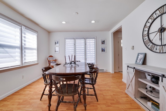 dining area with a baseboard heating unit, recessed lighting, light wood-type flooring, and baseboards