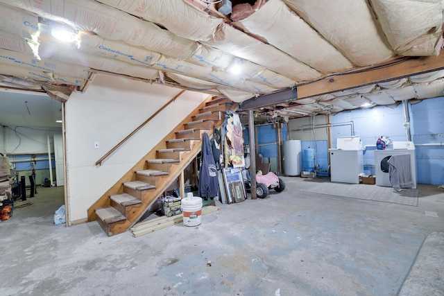 unfinished below grade area featuring stairway, gas water heater, and washer and dryer