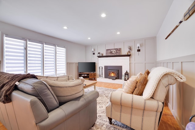 living room with a wainscoted wall, recessed lighting, light wood-style flooring, and a decorative wall