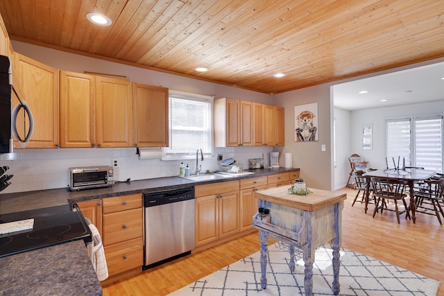 kitchen with appliances with stainless steel finishes, light wood-style floors, a wealth of natural light, and decorative backsplash