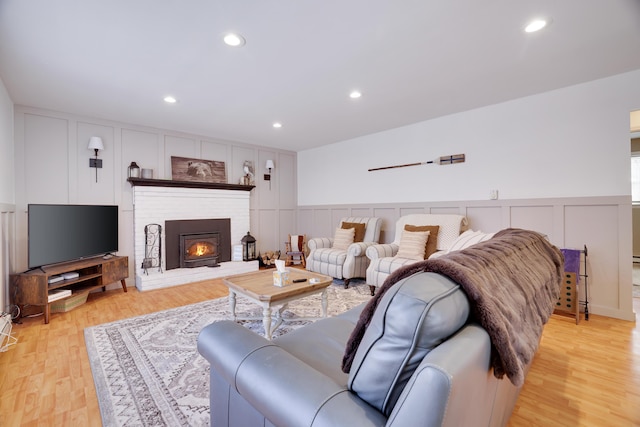 living room featuring light wood-type flooring, a decorative wall, and recessed lighting