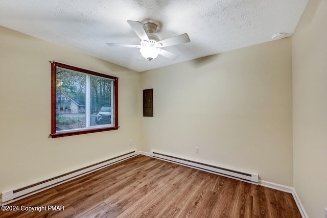 spare room featuring ceiling fan, baseboard heating, wood finished floors, and a textured ceiling