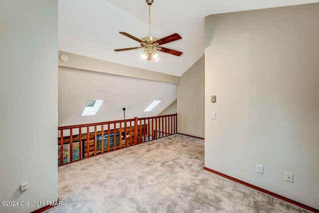 bonus room with baseboards, lofted ceiling with skylight, carpet floors, and ceiling fan