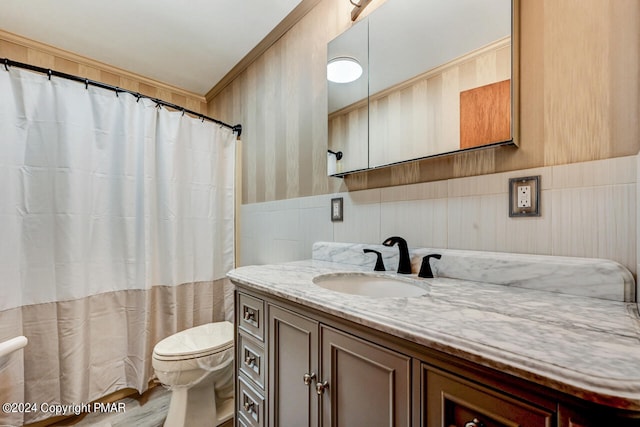 bathroom featuring wainscoting, toilet, vanity, and a shower with curtain