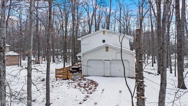 view of snow covered exterior featuring a garage