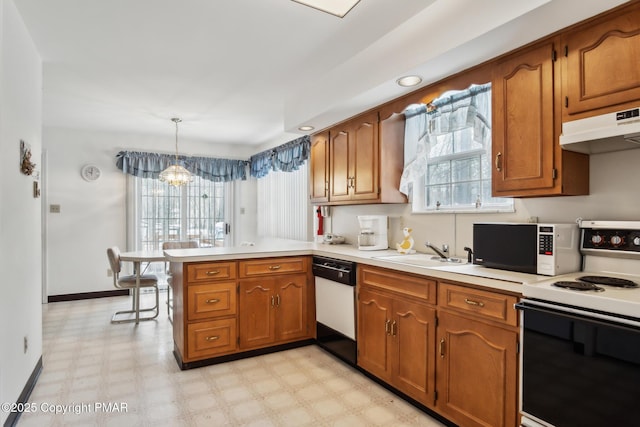 kitchen featuring sink, white appliances, hanging light fixtures, kitchen peninsula, and a chandelier