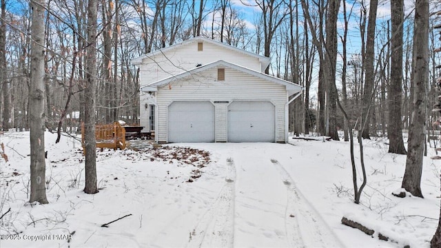 view of snowy exterior featuring a garage