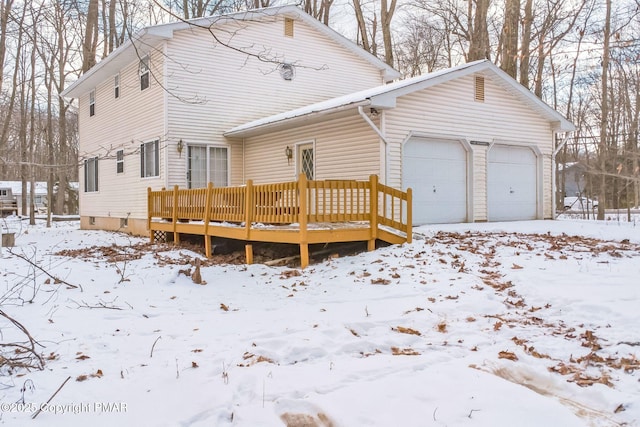 snow covered back of property with a wooden deck