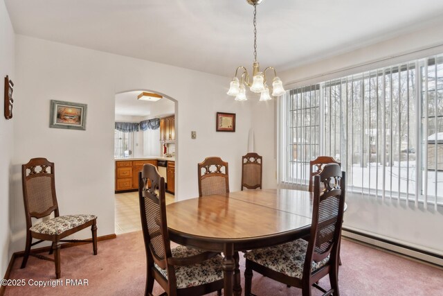 carpeted dining area with a baseboard heating unit and an inviting chandelier