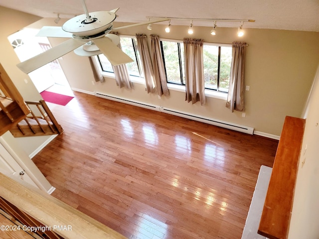 interior space featuring a ceiling fan, baseboards, hardwood / wood-style floors, and baseboard heating