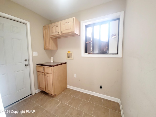 washroom with hookup for a washing machine, laundry area, baseboards, and light tile patterned floors