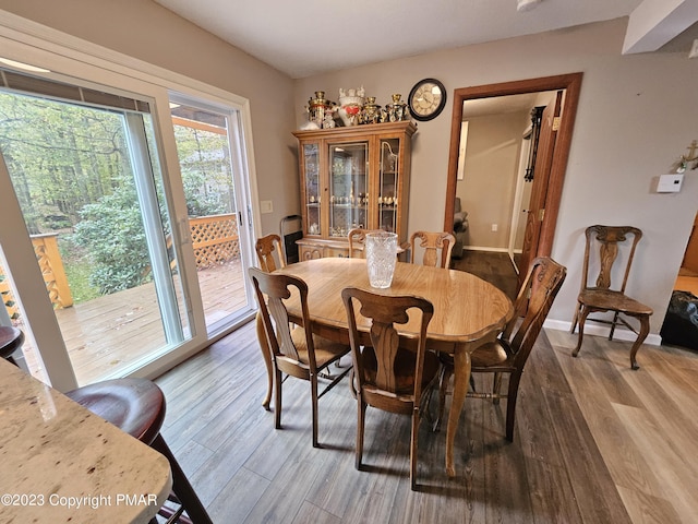 dining area with baseboards and wood finished floors