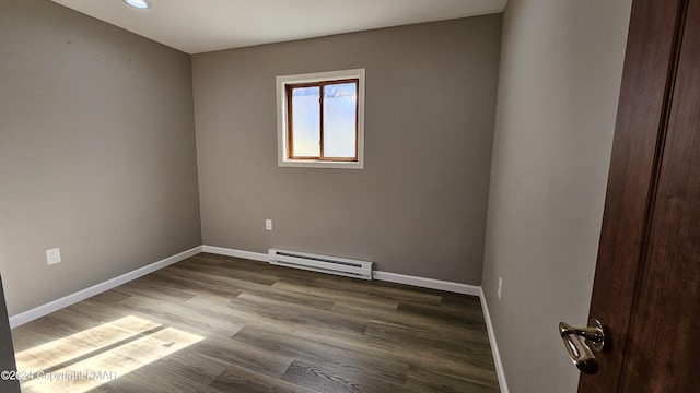 unfurnished room with baseboards, a baseboard heating unit, and dark wood-type flooring