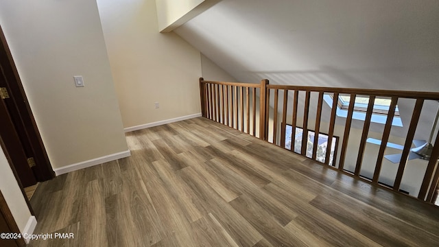 additional living space featuring baseboards, vaulted ceiling, and wood finished floors