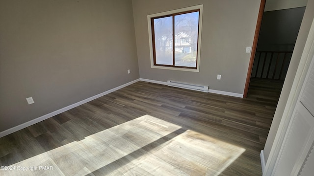 unfurnished room featuring a baseboard radiator, baseboards, and wood finished floors