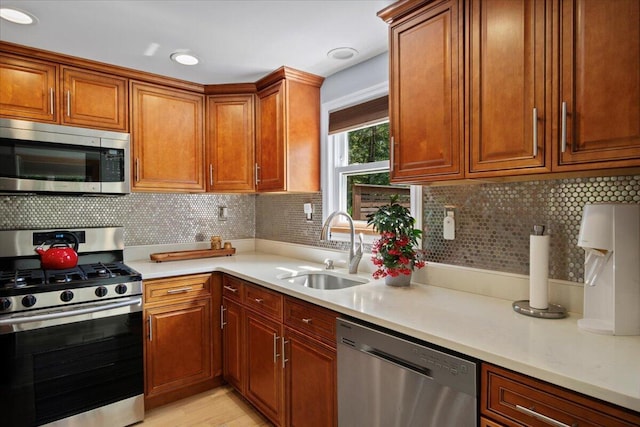 262 Marilou Ln, Bartonsville, PA 18321 - kitchen with appliances with stainless steel finishes, light countertops, backsplash, brown cabinets, and light wood-style flooring