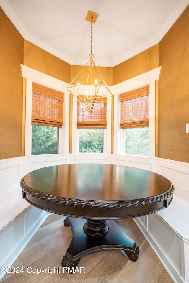 dining room featuring ornamental molding, breakfast area, wainscoting, and a healthy amount of sunlight