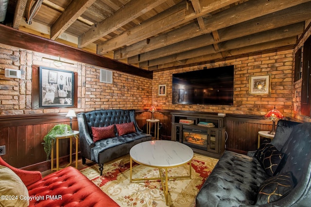 living room featuring brick wall, beamed ceiling, wainscoting, and wood ceiling