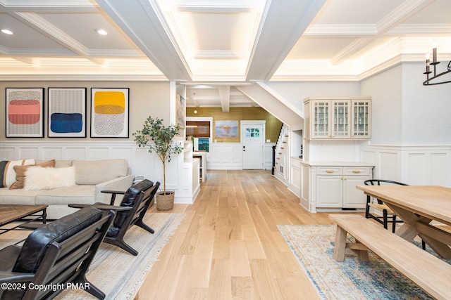 interior space with coffered ceiling, light wood-style flooring, a decorative wall, and beam ceiling