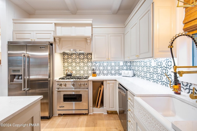 kitchen featuring white cabinetry, high end appliances, and decorative backsplash