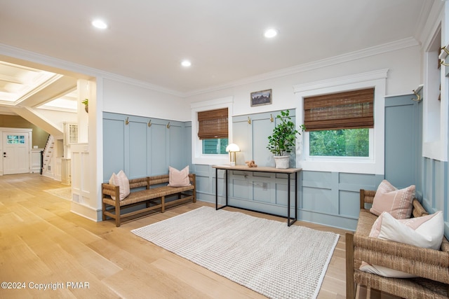 living area featuring light wood-type flooring and a decorative wall