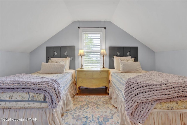 bedroom featuring lofted ceiling and wood finished floors