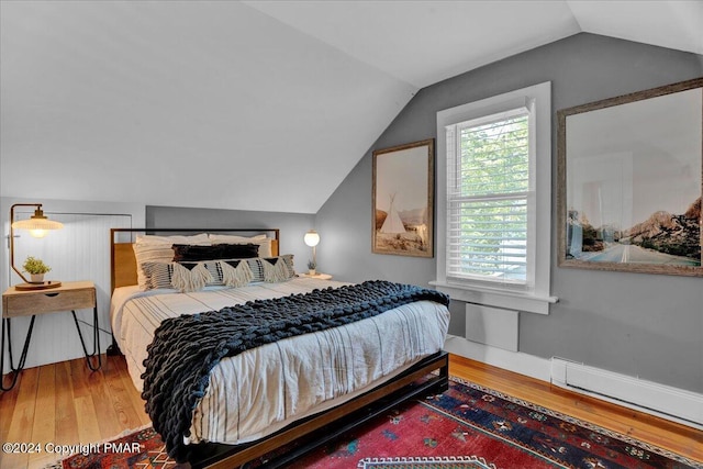 bedroom with vaulted ceiling, baseboards, and wood finished floors