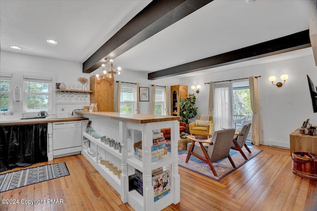 kitchen featuring a healthy amount of sunlight, white dishwasher, beamed ceiling, and open shelves