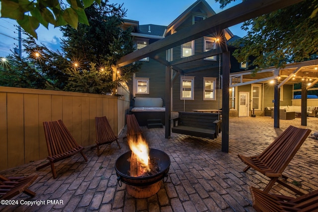 view of patio with an outdoor living space with a fire pit, fence, and a hot tub