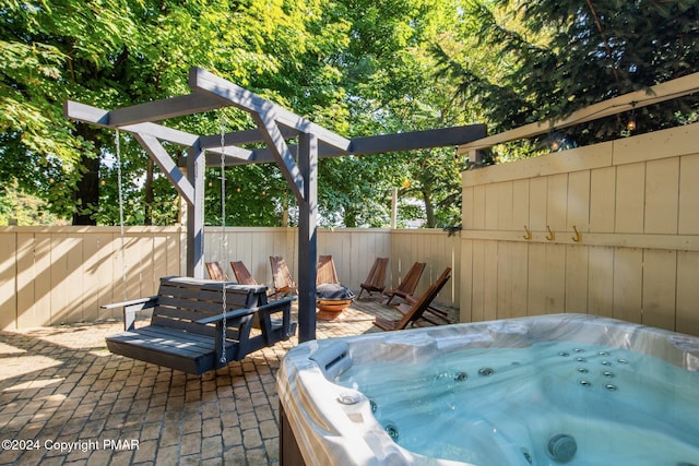 view of patio / terrace featuring a hot tub and fence