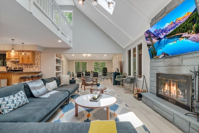 171 Flintlock Trl, Pocono Pines, PA 18350 - living area featuring high vaulted ceiling, a stone fireplace, plenty of natural light, and a skylight