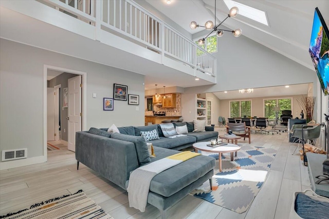 171 Flintlock Trl, Pocono Pines, PA 18350 - living area featuring a chandelier, high vaulted ceiling, light wood finished floors, baseboards, and a skylight