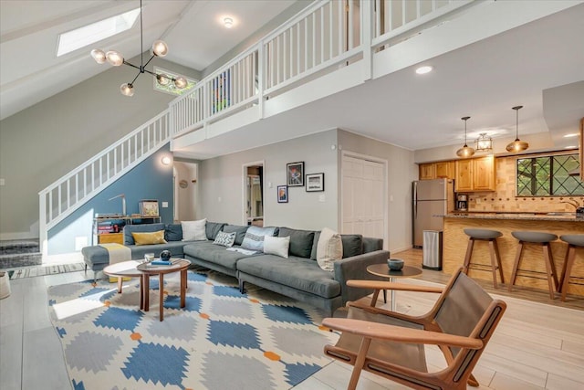 171 Flintlock Trl, Pocono Pines, PA 18350 - living room featuring stairs, high vaulted ceiling, light wood finished floors, a skylight, and healthy amount of natural light