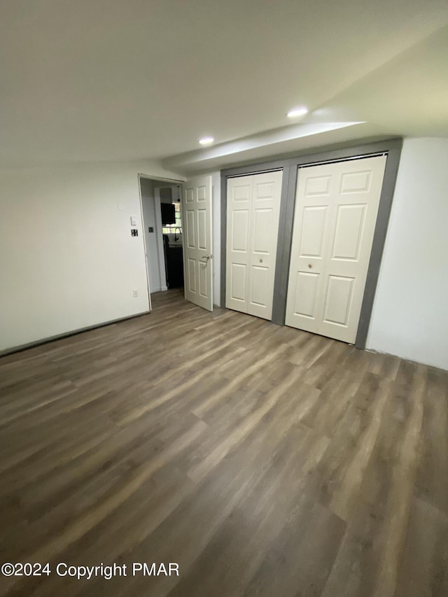 unfurnished bedroom with multiple closets, wood finished floors, and recessed lighting