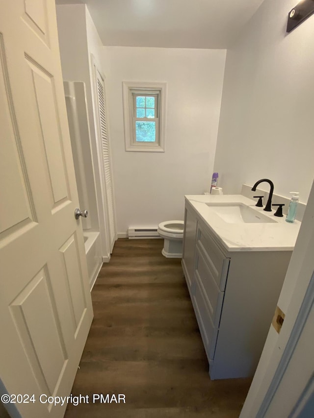 full bathroom with shower / bath combo, toilet, wood finished floors, vanity, and a baseboard heating unit