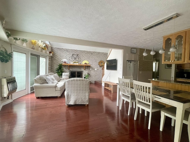 5144 Hounds Ear Rd, Tobyhanna, PA 18466 - living room featuring dark wood-style flooring, heating unit, brick wall, and a textured ceiling
