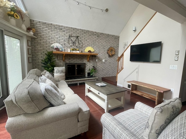 5144 Hounds Ear Rd, Tobyhanna, PA 18466 - living area featuring vaulted ceiling, brick wall, a fireplace, stairs, and wood finished floors