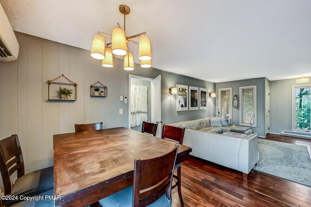 dining area with an inviting chandelier, dark wood-style flooring, and an AC wall unit