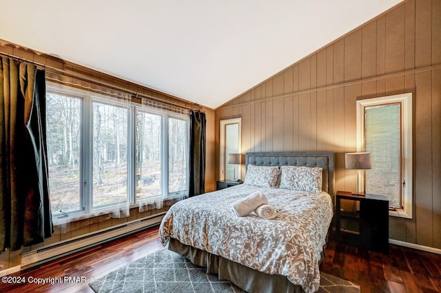 bedroom with lofted ceiling, wood-type flooring, wooden walls, and baseboard heating