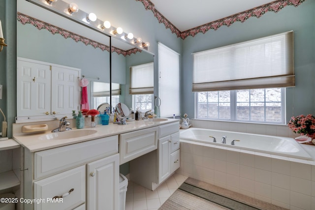 bathroom with double vanity, tile patterned flooring, a sink, and a bath