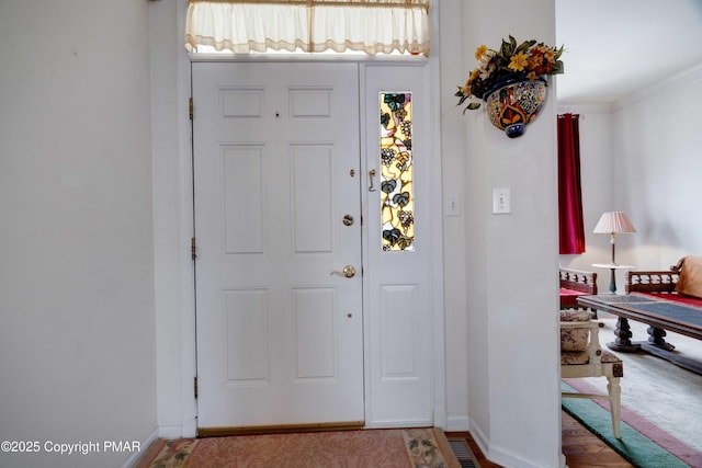 foyer entrance featuring baseboards and ornamental molding