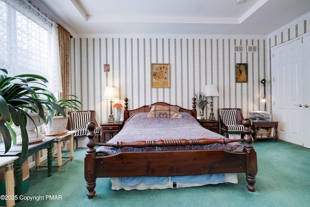 bedroom with carpet floors, a tray ceiling, crown molding, and wallpapered walls