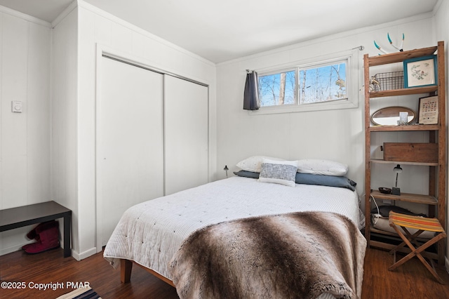 bedroom featuring ornamental molding, a closet, and wood finished floors